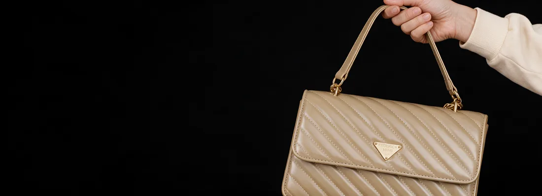 Mano sosteniendo la cartera Mimi caqui sobre fondo negro
